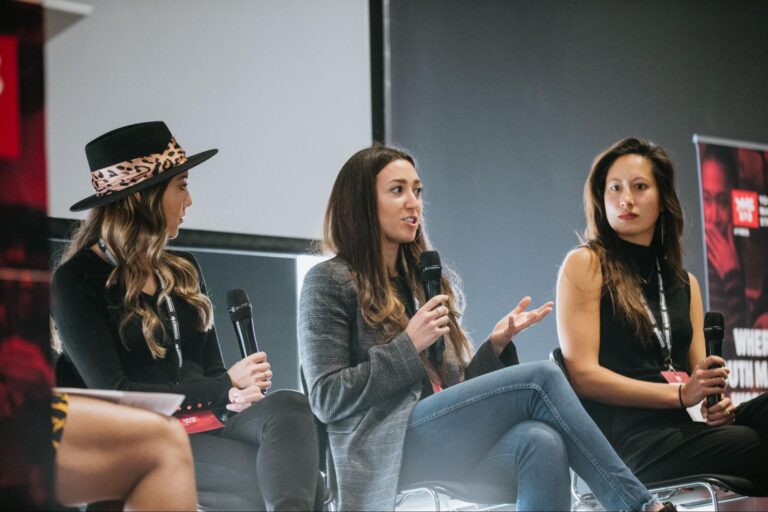 three women speaking on stage