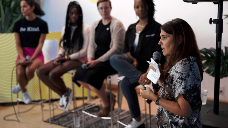 A person speaking at an event while others listen