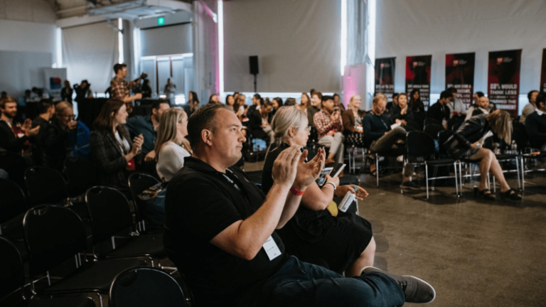 Guests at a business event applaud speakers