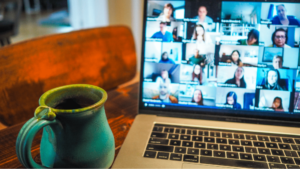 Mug sitting on desk next to laptop with Zoom conference on screen