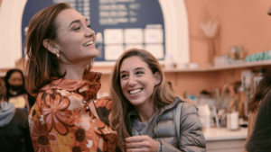 Two women laughing at an event