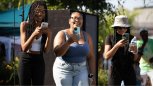 three attendees holding their phones